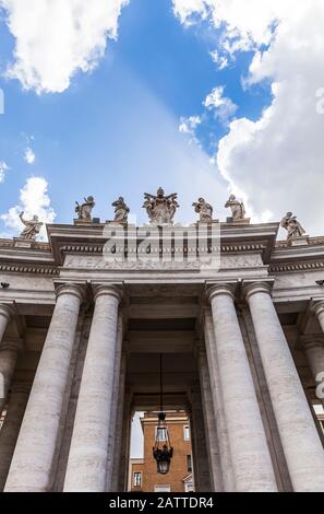 L'entrée sud de la place Saint-Pierre à travers la colonnade, marquée par un manteau d'armes d'Alexandre VII, Cité du Vatican, Rome, Italie. Banque D'Images