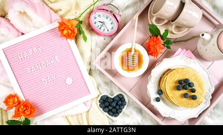 Plateau de petit-déjeuner pancake au lit avec sirop et bleuets fruits mise en page plate vue sur le dessus, avec lettre feutre planche Happy Pancake message de jour. Banque D'Images