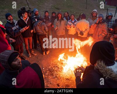 Les gens qui se réchauffent au camp de réfugiés d'Usivak près de Sarajevo.En Bosnie-Herzégovine, environ 8 000 réfugiés et migrants tentent de trouver un moyen de traverser la frontière avec la Croatie et d'aller plus loin vers les pays d'Europe occidentale. Certains d'entre eux vivent dans des camps de réfugiés surpeuplés, certains d'entre eux sont squatés dans des bâtiments abandonnés ou dorment simplement dans les rues. Beaucoup d'entre eux rapportent que s'ils sont pris à la frontière par la police croate, ils sont battus, leur argent comptant, les smartphones et les objets de valeur sont volés, les vestes et les chaussures sont brûlés et ils sont battus par les gardes-frontières. Banque D'Images