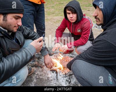 Les gens qui se réchauffent dans le camp de réfugiés d'Usivak près de Sarajevo.En Bosnie-Herzégovine, environ 8 000 réfugiés et migrants tentent de trouver un moyen de traverser la frontière avec la Croatie et d'aller plus loin vers les pays d'Europe occidentale. Certains d'entre eux vivent dans des camps de réfugiés surpeuplés, certains d'entre eux sont squatés dans des bâtiments abandonnés ou dorment simplement dans les rues. Beaucoup d'entre eux rapportent que s'ils sont pris à la frontière par la police croate, ils sont battus, leur argent comptant, les smartphones et les objets de valeur sont volés, les vestes et les chaussures sont brûlés et ils sont battus par les gardes-frontières. Banque D'Images