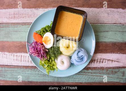 Cuisine thaïlandaise délicieuse et belle nourriture / nouilles de riz colorées ou riz thaïlandais vermicelles nouilles et poisson crabe curry sauce soupe avec légumes sur plaque WO Banque D'Images