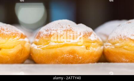 Vue latérale sur le Krapfen traditionnel autrichien (aussi: Berliner, anglais: Beignet). Gros plan de sucré frit rempli de marmalade. Populaire pendant le carnaval Banque D'Images