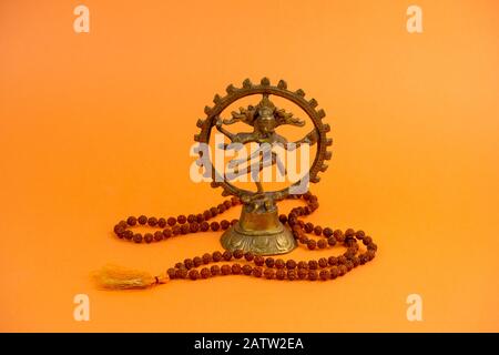 Statue de danse Dieu Shiva et perles de prière traditionnelles rudraksha sur fond orange , carte de salutation Shivaratri Banque D'Images