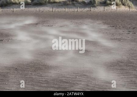 Sable soufflant sur une plage venteuse Banque D'Images