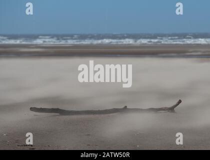 Sable soufflant sur une plage venteuse Banque D'Images