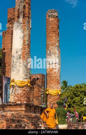 Ayutthaya, Thaïlande - 1 janvier 2016 : moine bouddhiste en robe orange avec les ruines du temple Wat Thammicarat sur le fond Banque D'Images