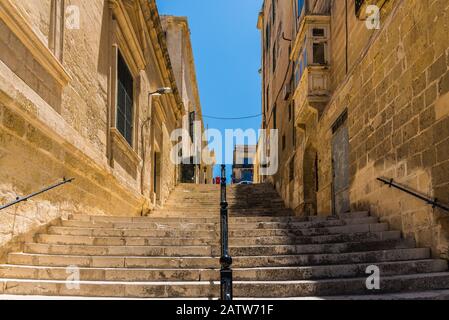 Escalier de rue entre deux vieux bâtiments avec balcons et fenêtres fermées avec volets Banque D'Images