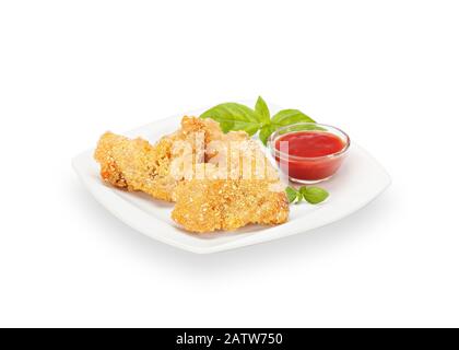 Ailes de poulet croustillant frit chaud dans une assiette blanche avec basilic et ketchup. Viande Croquante Panée Faite De Ailes De Poulet. Isolé sur blanc Banque D'Images