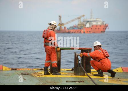 équipage marin effectuant des opérations de manutention d'ancre en mer pour un bateau de travail à ancre à quatre points en mer Banque D'Images