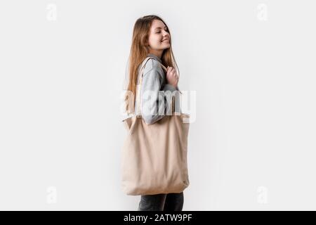 Jeune femme avec sac de shopping en toile. Style de vie écologique. Arrière-plan blanc isolé Banque D'Images