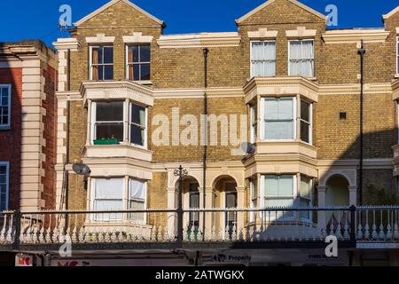 Beau défilé de magasins sur Monson Road, Tunbridge Wells, avec des appartements au-dessus avec un balcon et balustrade décorative en fer Forgé, Kent, Royaume-Uni Banque D'Images