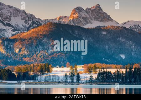 Lever du soleil d'hiver au lac Hopfen avec les montagnes Karwendel en arrière-plan, Bavière, Allemagne. Banque D'Images