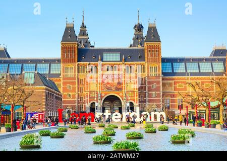 Amsterdam, Pays-Bas - 31 mars 2016 : l'eau et de fleurs, le Rijksmuseum et les gens en face de l'écriture, Amsterdam, Museumplein, Holland Banque D'Images