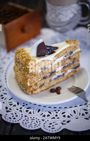 Gâteau au miel et pruneaux sur une plaque blanche Banque D'Images