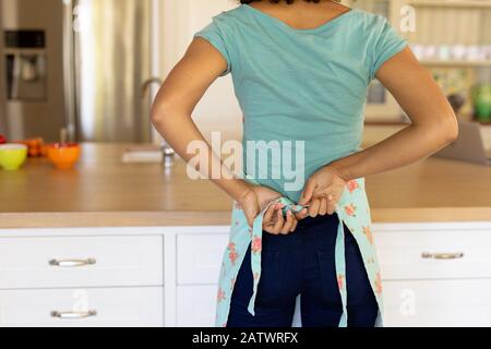 Jeune femme portant un tablier dans la cuisine Banque D'Images