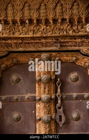 Inde, Rajasthan, Shekhawati, Dundlod, Tunanram Goenka (seth rus Das) Haveli, maison restaurée de riche marchand, vieux détail de porte en bois Banque D'Images