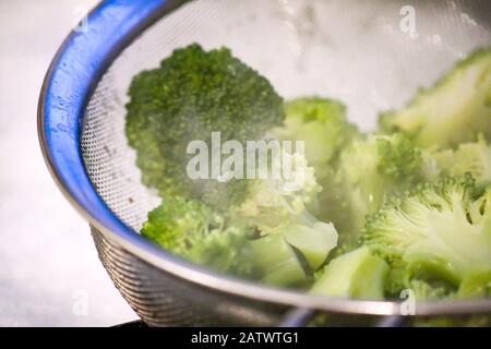 brocoli cuit drainant dans un métal corrosif Banque D'Images