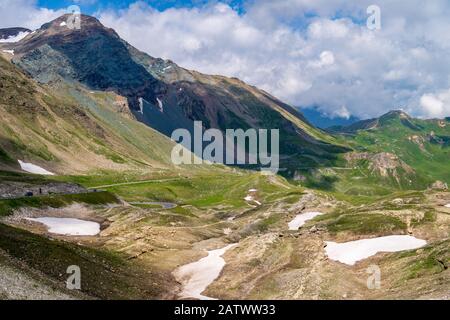 Flanc de montagne vert avec des patchs de neige le long de Grossglockner High Alpine Road, Alpes autrichiennes Banque D'Images