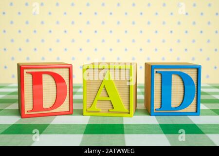 Enfant bois ABC blocs orthographe DAD sur une nappe à carreaux Banque D'Images