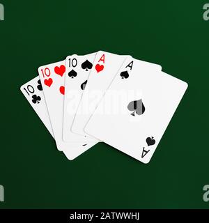 Main pleine de poker maison de jouer des cartes sur un fond vert baiser Banque D'Images