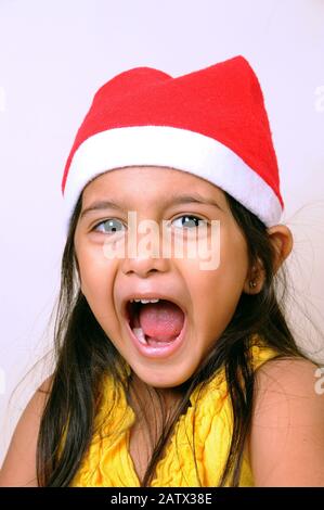 Mumbai, Maharashtra, Inde- Asie, 29 décembre 2014 - Heureuse petite fille indienne portant Red Santa Claus Hat célébrant le festival de Noël. Banque D'Images