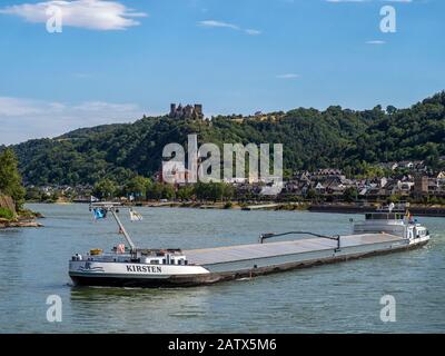 OBERWESEL, ALLEMAGNE - 06 JUILLET 2019 : barge de cargaison sur le Rhin avec le village d'Oberwesel et le château de Schönburg en arrière-plan Banque D'Images