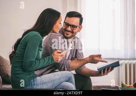 Un couple heureux est assis au canapé dans sa maison et se détendre. Banque D'Images