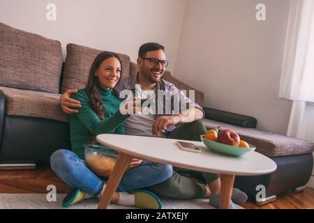 Couple est relaxant à la maison. Ils regardent la télévision. Banque D'Images