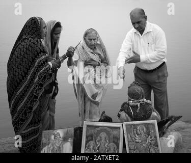 Les dévotés en pèlerinage paient leur respect et leurs offrandes votives aux dieux hindous le long de la rive de la rivière à l'aube à Vrindavan, Uttar Pradesh, Inde. Banque D'Images