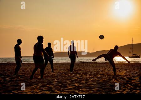 Silhouettes de personnes jouant au football sur la plage à Elafonissos, Péloponnèse, Grèce Banque D'Images