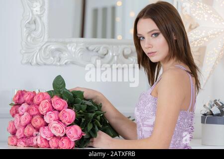 Portrait d'une belle femme avec un bouquet de roses. Fille avec fleurs Banque D'Images