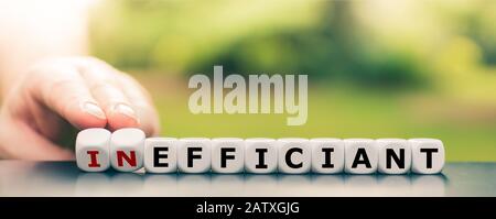 La main tourne les dés et change le mot « inefficace » en « efficace ». Banque D'Images