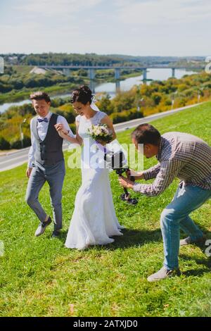 Photographe de mariage prenant des photos de la mariée et du marié une colline Banque D'Images