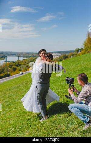 Photographe de mariage prenant des photos de la mariée et du marié une colline Banque D'Images