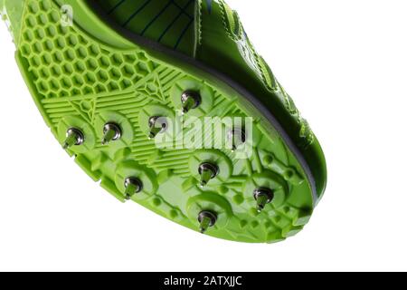 Fragment d'une sneaker verte brillante avec pointes sur fond blanc. Chaussures de sport. Banque D'Images