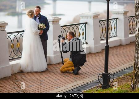 Photographe de mariage prenant des photos de la mariée et du marié allée du parc Banque D'Images