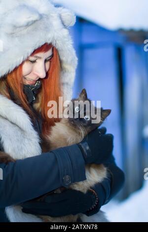 Biélorussie, la ville de Gomil, 13 janvier 2019. Rite d'une soirée généreuse. Cérémonie de Kalyada. La femme en hiver tient un chat dans ses bras Banque D'Images