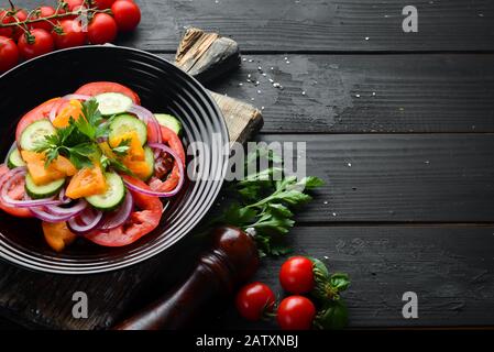 Salade de légumes. Tomates, concombre, oignons, persil. Vue de dessus. Espace libre pour votre texte. Banque D'Images