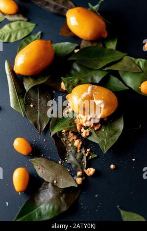 Dessert Brisé À Base De Citron Naturel, De Citron Vert Ou De Curd Et De Meringue Italienne À L'Intérieur. Citrons Et Kumquats Sur Les Feuilles Et Le Fond Noir. Moderne Banque D'Images