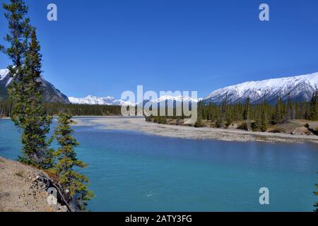 Magnifique rivière bleue Siffleur avec de hautes montagnes couvertes de neige en arrière-plan. Journée ensoleillée, ciel bleu, Réserve écologique des plaines Kootenay. Canada Banque D'Images