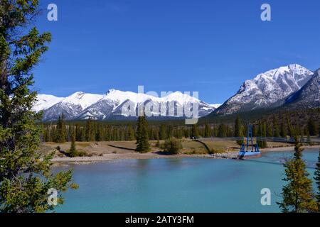 Magnifique rivière bleue Siffleur avec de hautes montagnes couvertes de neige en arrière-plan. Journée ensoleillée, ciel bleu, Réserve écologique des plaines Kootenay. Canada Banque D'Images