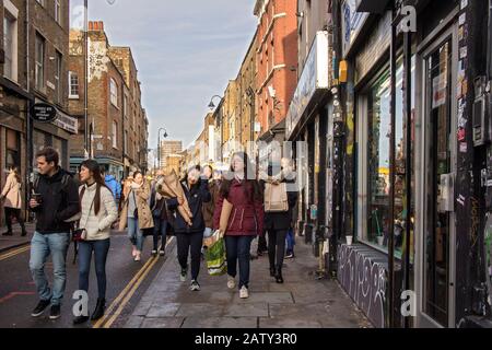 Londres, Royaume-Uni, - 23 décembre 2019, les filles asiatiques avec bouquets de fleurs marchent le long de Brick Lane Banque D'Images