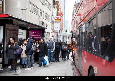 Londres, Royaume-Uni, - 23 décembre 2019, Les Gens de tous âges attendent un bus à un arrêt près de Liverpool Street. Banque D'Images