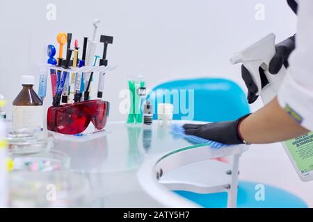 Kiev UA, 31-07-2019. Mains de l'infirmière stérilisation de la surface du bureau de travail des médecins de dentiste. Gros plan sur le bureau de travail du dentiste avec composite dentaire Banque D'Images