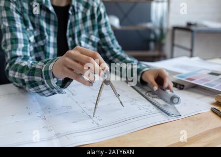 Concevoir des plans de travail au bureau. Concevoir un projet de construction par un ingénieur. Plan architectural. Gros plan portrait de belle femme de la concentricité Banque D'Images