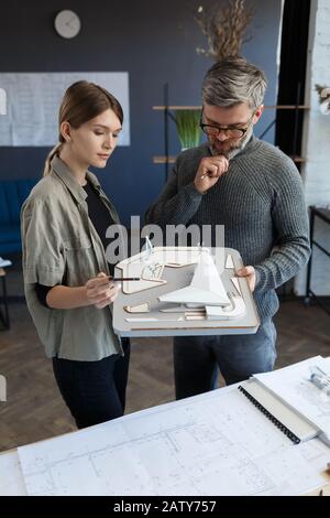 équipe d'architectes en trois dimensions travaillant au bureau avec un modèle en trois dimensions. Les architectes inspectent la mise en page du bâtiment, planifient le projet de construction et recherchent de nouvelles idées. P Banque D'Images