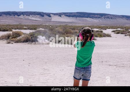 Petite fille pratiquant le tir de cible avec pistolet de calibre 22 LR dans un endroit désert du sud de l'Oregon Banque D'Images