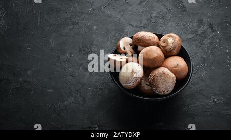 Champignons dans une assiette. Champigeons sur le vieux fond. Vue de dessus. Espace de copie disponible. Banque D'Images