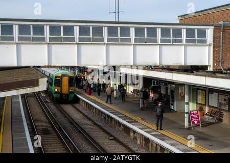 Les passagers des trains qui attendent sur une plate-forme de gare quand un train arrive Banque D'Images