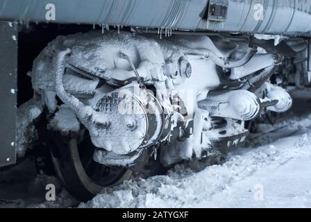 bogie recouverte de glace et de neige d'un transport ferroviaire de passagers sur rails pendant l'utilisation en hiver Banque D'Images